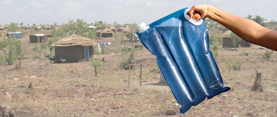 SolarSack posen holdes op foran en afrikansk landsby