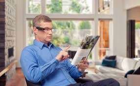 Mand med OrCam monteret på sine briller læser i et blad