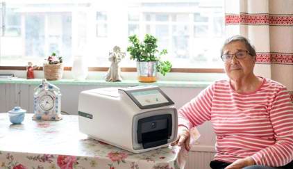 Ældre kvinde med Smila på køkkenbordet